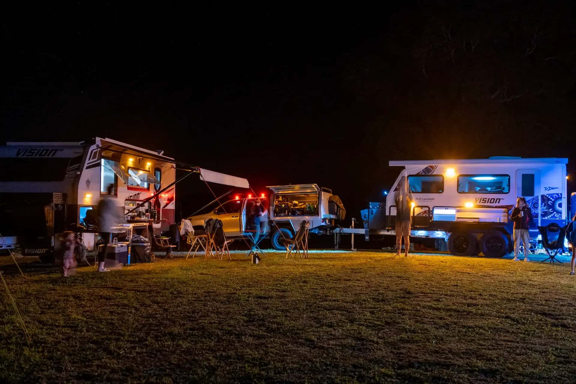 Elysium and Nirvana vans corralled at night camp